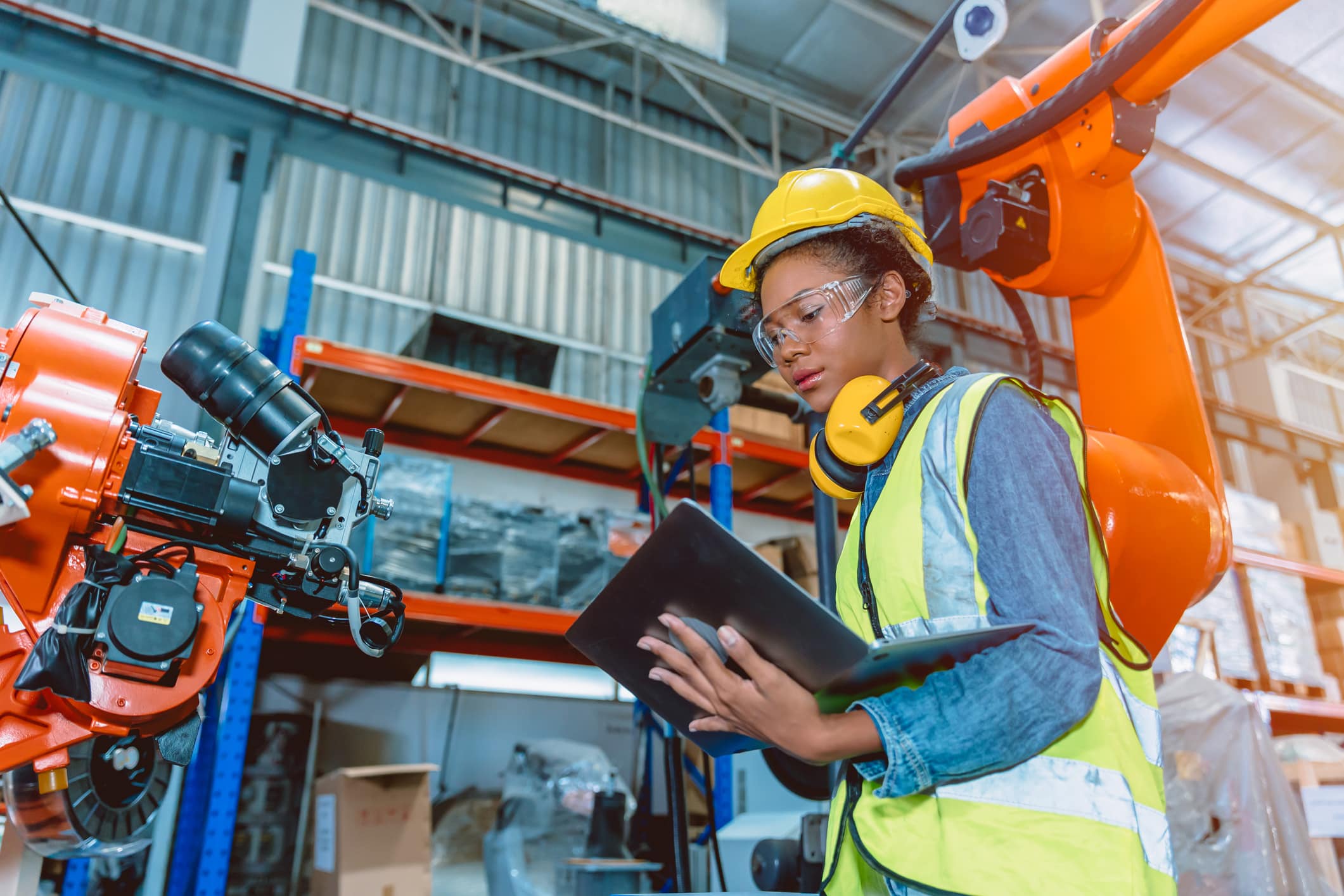 Woman programming robotic welding machine.
