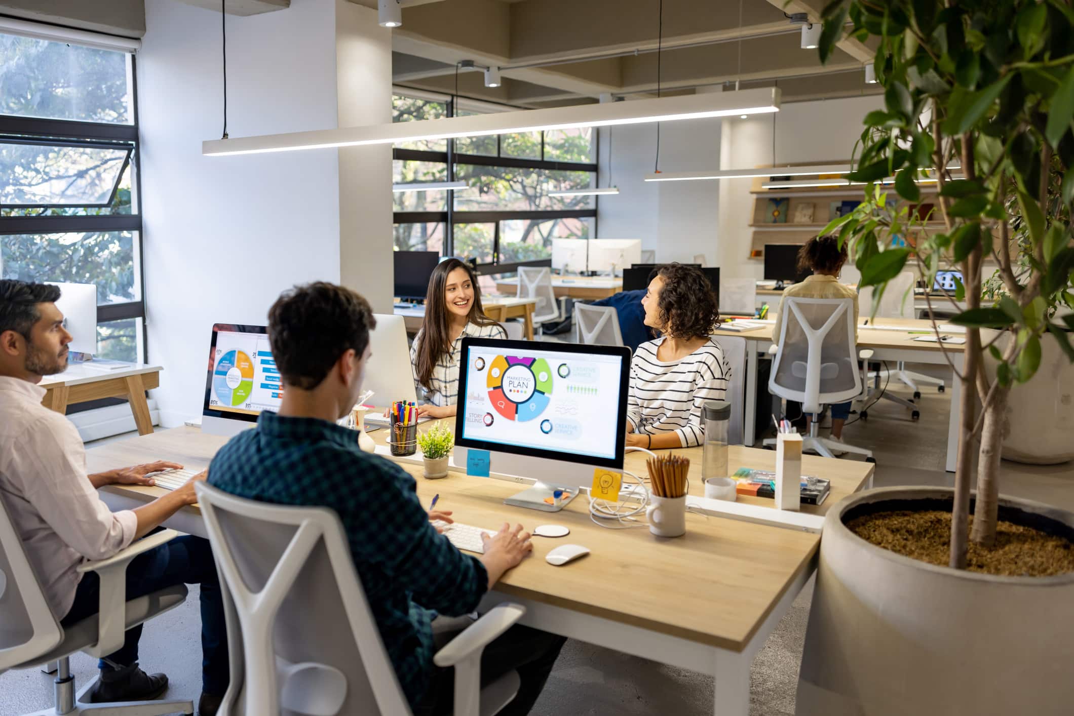 Happy group of people at a coworking office smiling while working