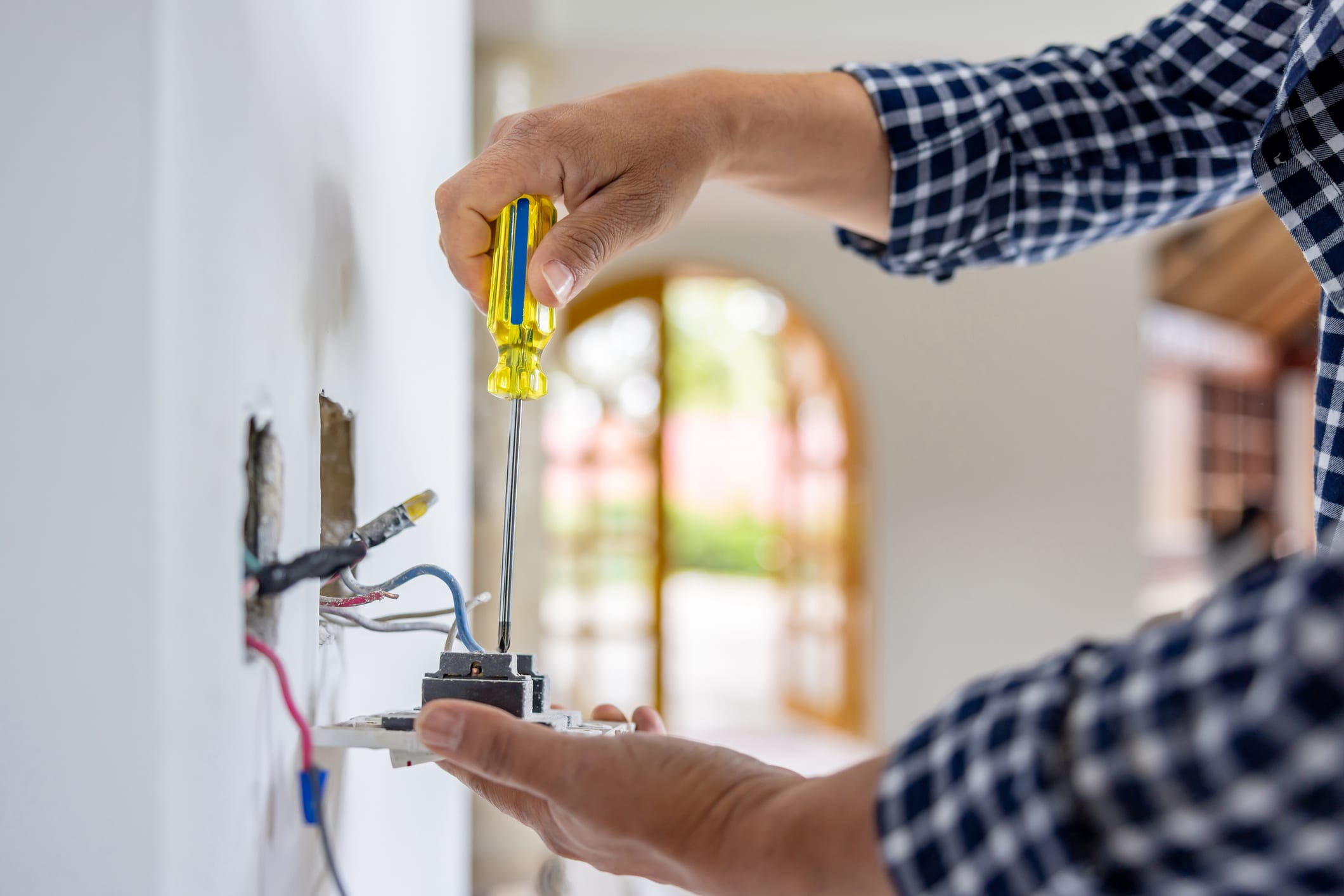 Close-up on an electrician installing a power outlet while remodeling a house