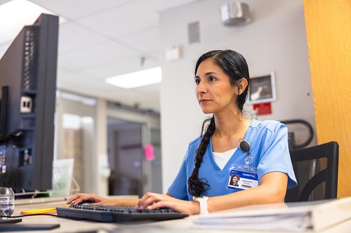 Nurses on computer managing the central hospital lobby in an ICU wing