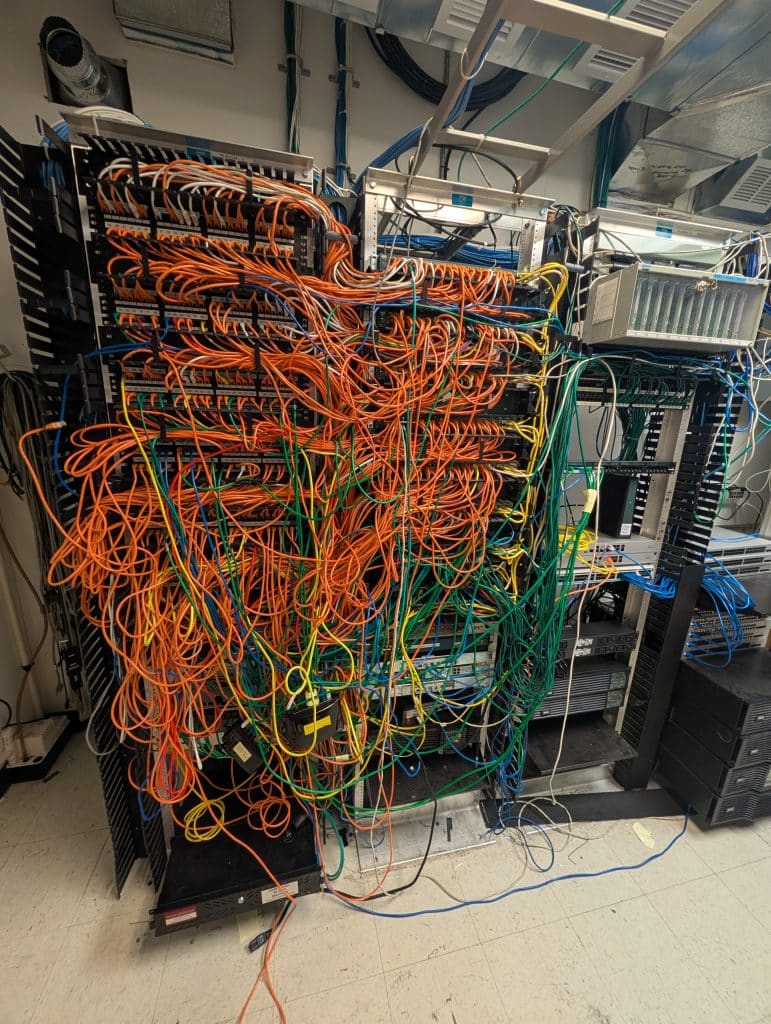 Before: network racks with tangled patch cables.